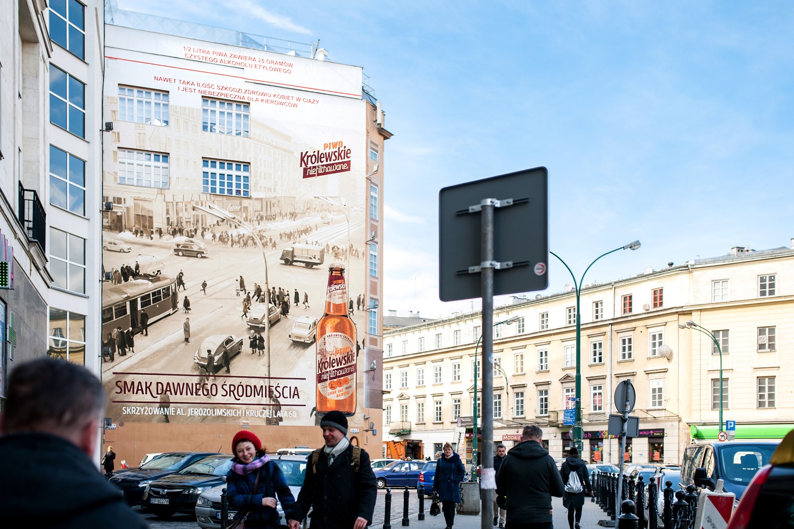 A view of a mural from Krucza street showing Historic Warsaw for Krolewskie Niefiltrowane brand | Ręcznie malowana kampania reklamowa dla marki Królewskie | Portfolio