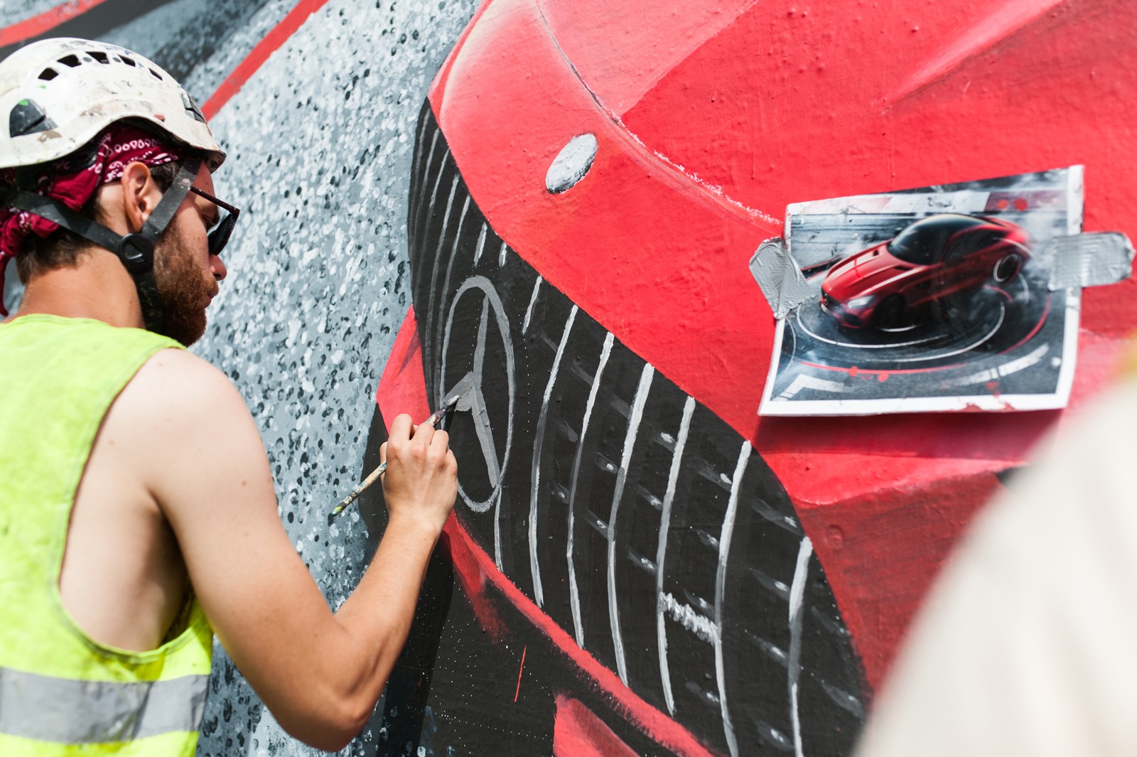 Artysta malujący mural na ulicy Brackiej dla marki Mercedes z samochodem Mercedes AMG | Kampania z wykorzystaniem murali na zlecenie Mercedes-Benz Polska | Portfolio