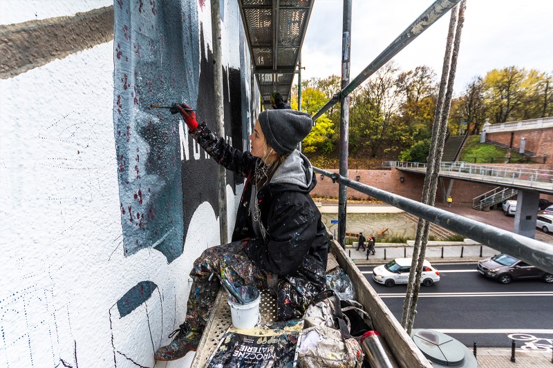Malarka przy pracy nad muralem  | Mroczne Materie | Portfolio