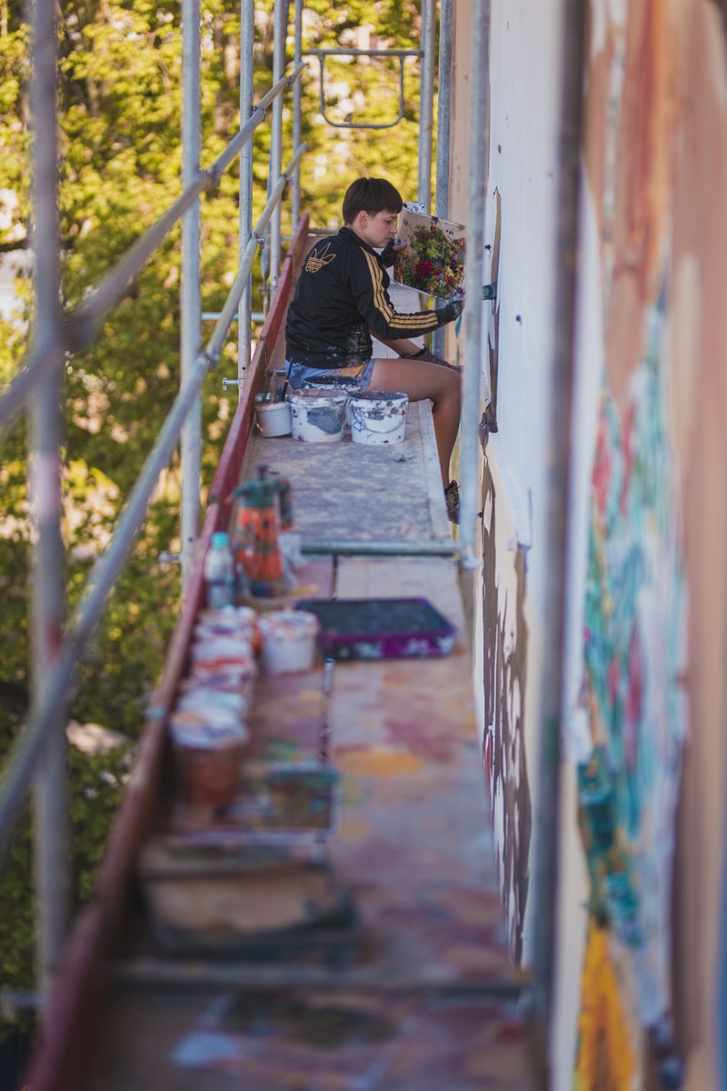 Malarz na rusztowaniu w trakcie prac na muralem na zamówienie Warszawa Jaworzyńska | Gardena | Portfolio