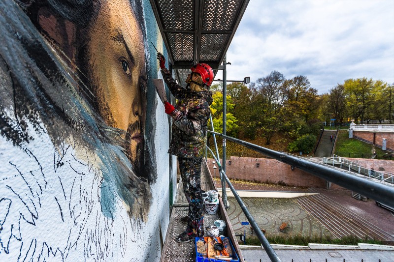 Malarz pracujący przy muralu  | Mroczne Materie | Portfolio