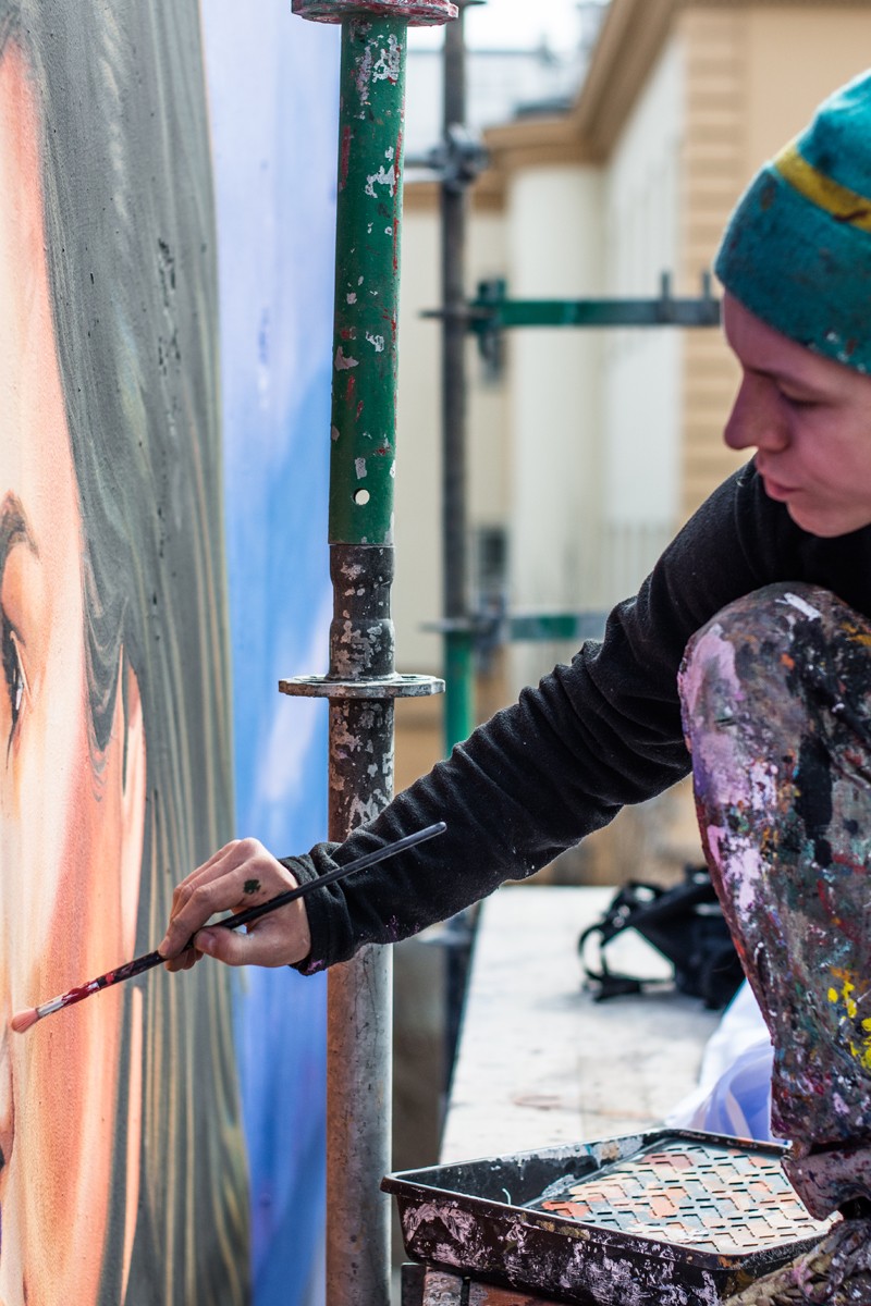 Ein Maler malt manuell das Gesicht eines Modells auf einem Werbemural | I love You Cindy | Portfolio