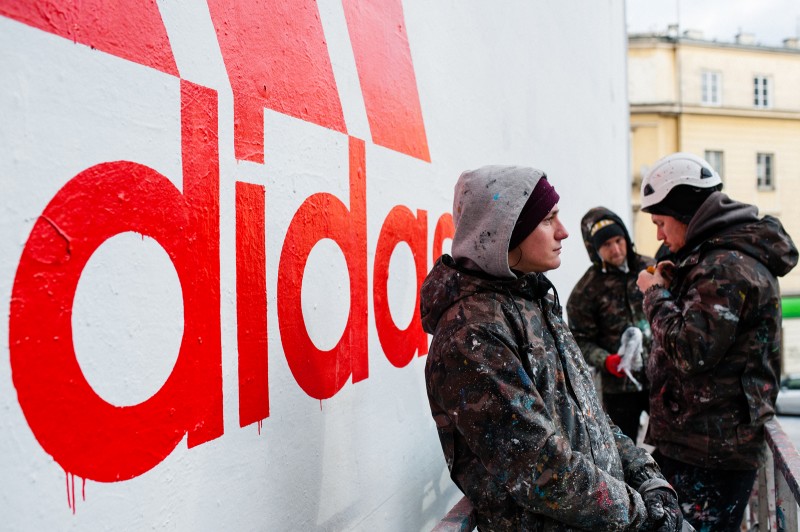 Painters during painting logo of Adidas Company on on a department store Bracia Jabłkowscy | Adidas - Here to Create | Portfolio