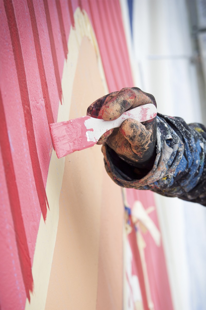 Painting a mural with a paintbrush on a wall on Nowomiejska street in Lodz | Costa Coffee's 1st Birthday | Portfolio