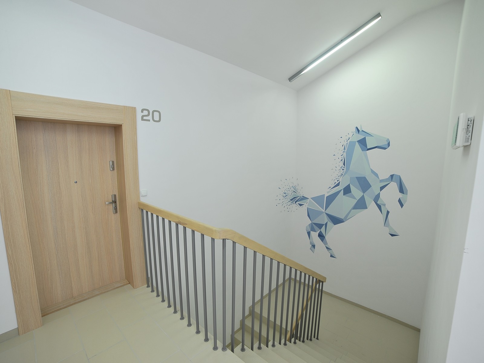 Mural artystyczny na klatce schodowej w Warszawie koń Osiedle Nowe Zamienie | Grafiki na ścianach malowane na zlecenie Pro Development | Portfolio