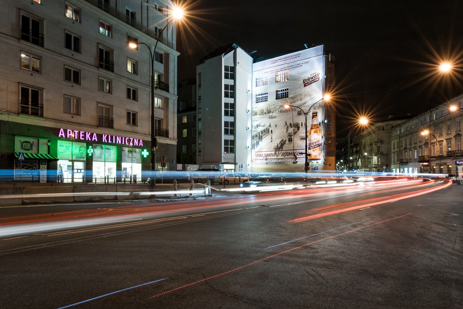 Night view of Warsaw’s city center with a mural painted for Krolewskie Niefiltrowane at the crossroads of Bracka and Krucza streets | Ręcznie malowana kampania reklamowa dla marki Królewskie | Portfolio