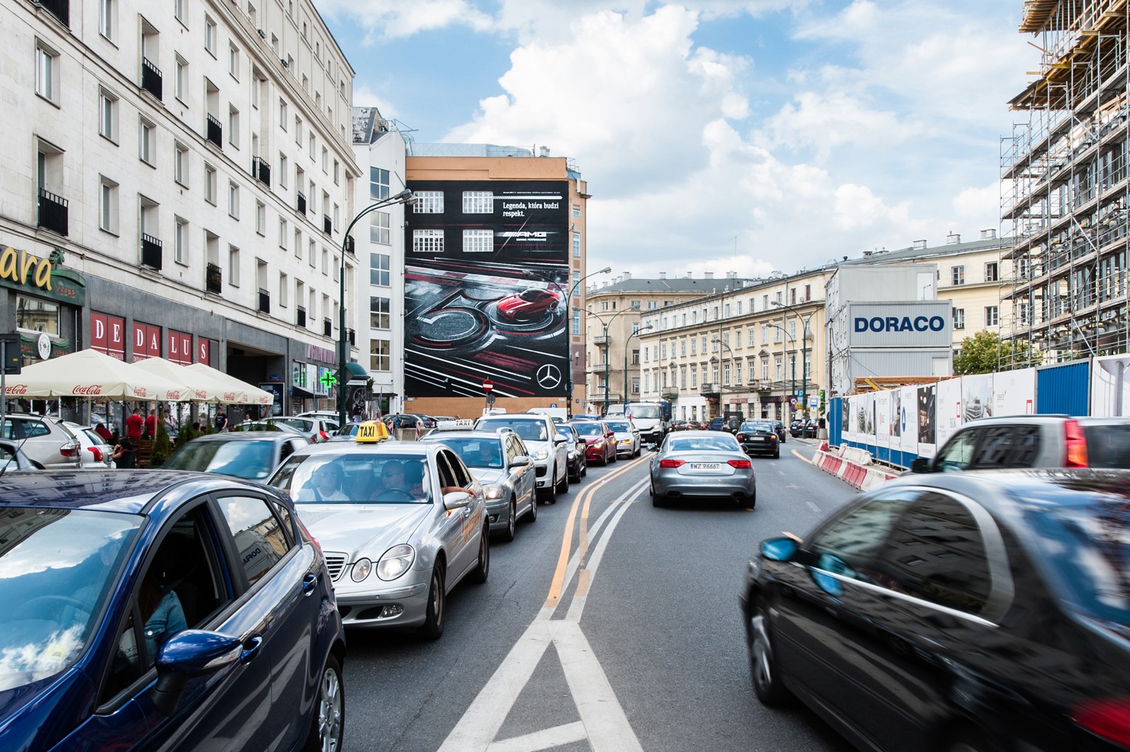 Widok z ulicy Kruczej na Dom Towarowy Bracia Jabłkowscy i mural reklamowy Mercedes AMG | Kampania z wykorzystaniem murali na zlecenie Mercedes-Benz Polska | Portfolio